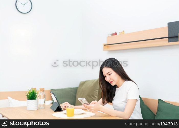 Living room concept a girl with long hair sitting in the living room surfing the internet with her smartphone.