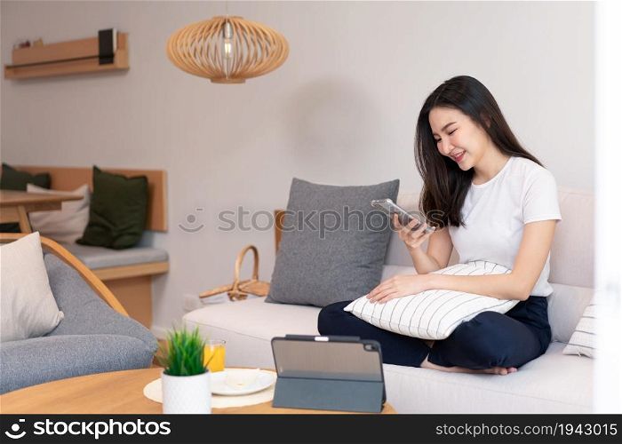 Living room concept a long-haired girl spending time on the electronic devices in the cozy room.