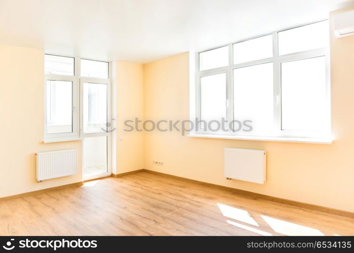 Living room interior. Living interior of empty room with wooden floor and light from the big white isolated windows