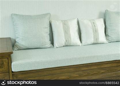living room interior with white and gray pillows on wooden sofa
