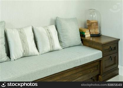 living room interior with white and gray pillows on wooden sofa