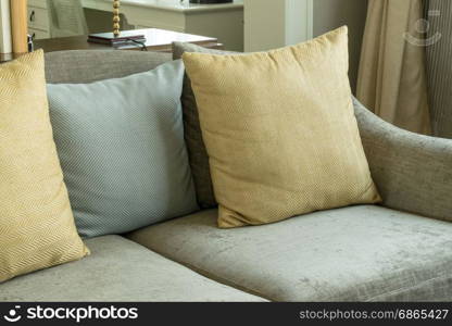 living room interior with yellow and gray pillows on velvet gray sofa