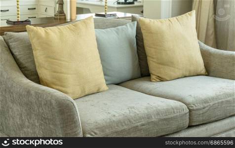 living room interior with yellow and gray pillows on velvet gray sofa