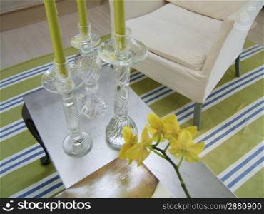 Living room table with candlesticks and armchair on a striped rug