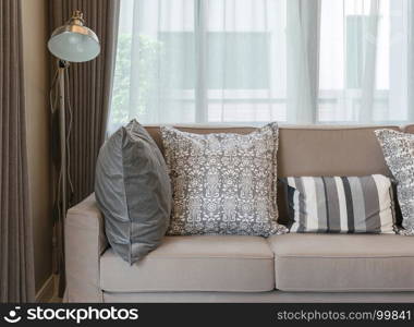 living room with brown sofa and grey patterned pillows