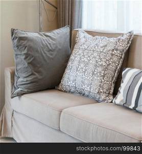 living room with brown sofa and grey patterned pillows