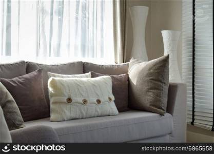 living room with row of grey pillows on sofa at home