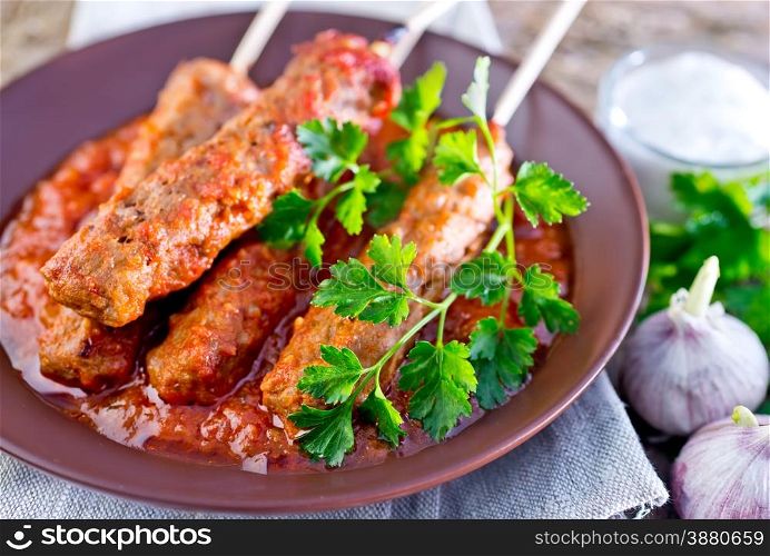 Ljulja-kebab with tomato sauce on the plate