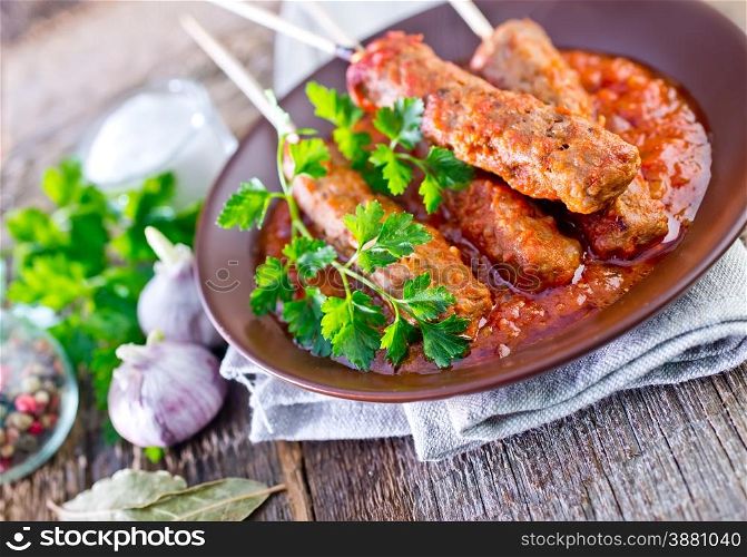 Ljulja-kebab with tomato sauce on the plate