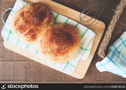 loaf of bread on wood background with bakery tools, flat lay, food closeup