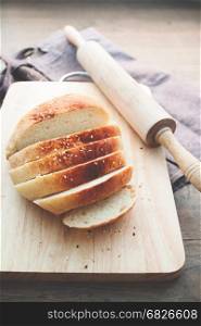loaf of bread on wood background with bakery tools, food concept