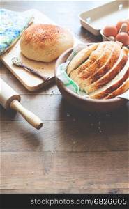loaf of bread on wood background with eggs and bakery tools with copy space