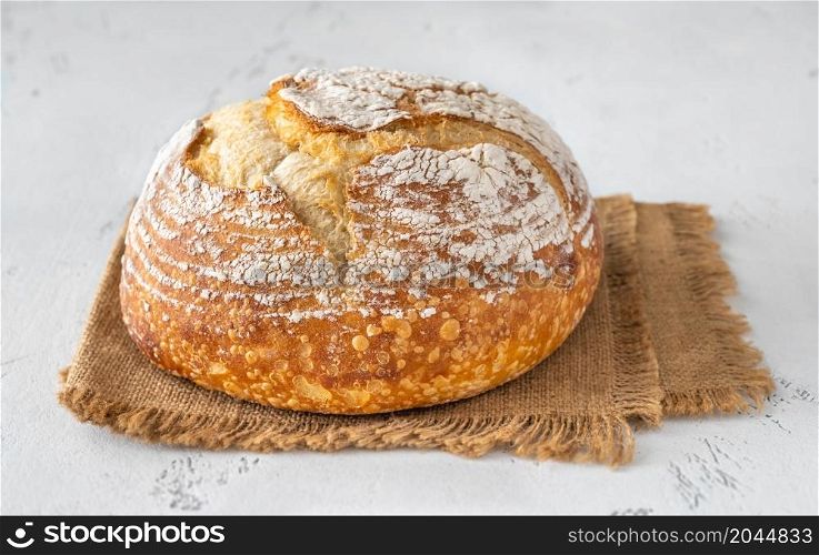 Loaf of fresh sourdough bread on white background
