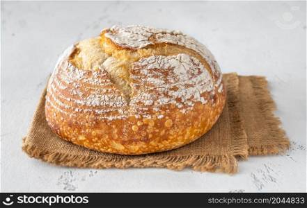 Loaf of fresh sourdough bread on white background