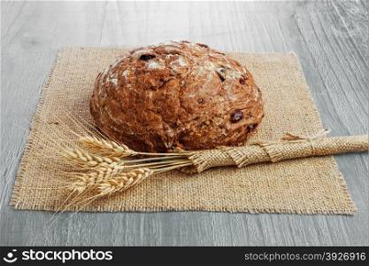 loaf of sour cherry and walnut rye bread on wooden background