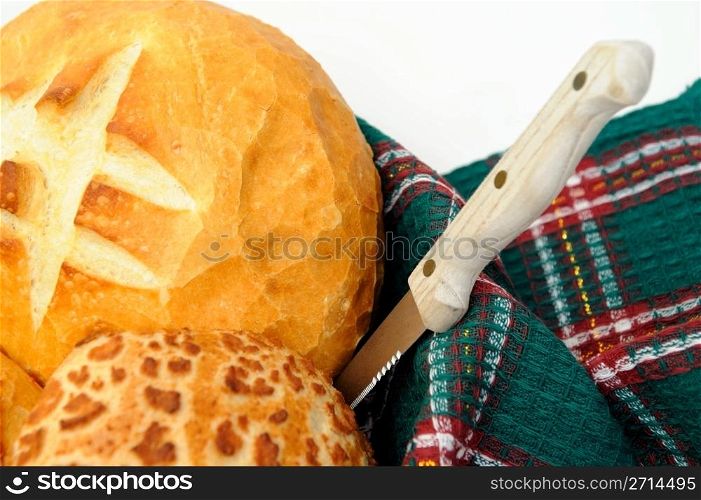 Loaf of sourdough bread and rolls in a basket with a knife ready to cut for sandwiches. Sourdough Bread