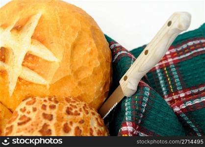 Loaf of sourdough bread and rolls in a basket with a knife ready to cut for sandwiches. Sourdough Bread