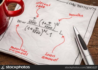 loan payment equation sketched on a white napkin with a cup of coffee