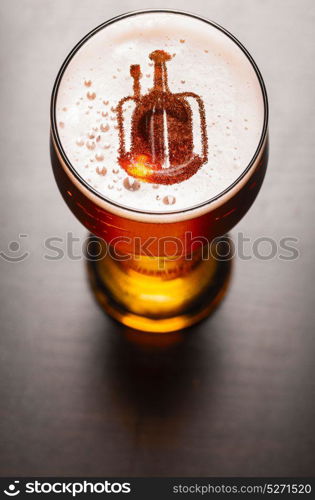 Local craft beer. Brewery silhouette in glass of fresh beer on pub table, view from above. Local craft beer