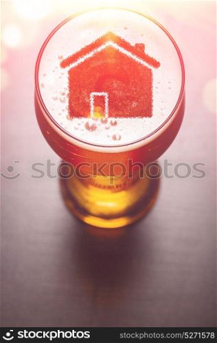 Local craft beer. House silhouette in glass of fresh beer on pub table, view from above. Local craft beer