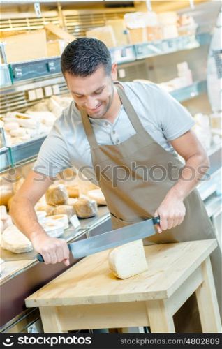 Local deli worker slicing some cheese