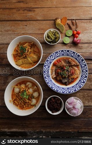 Local northern Thai food Egg noodle curry with chicken and meatball and Rice noodles on wood background