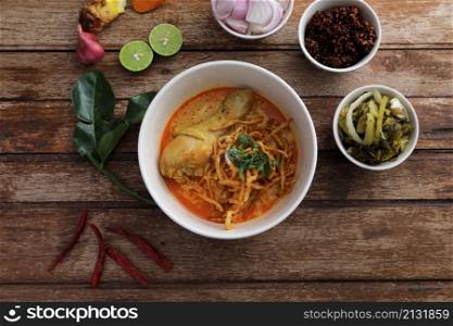 Local northern Thai food Egg noodle curry with chicken on wood background