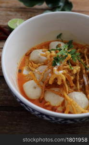 Local northern Thai food Egg noodle curry with meatballs on wood background