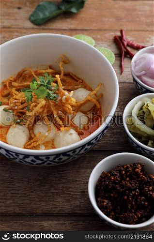 Local northern Thai food Egg noodle curry with meatballs on wood background