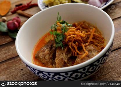 Local northern Thai food Egg noodle curry with pork ribs on wood background