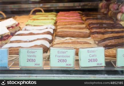 Local patiserie in Paris showing the typical french pastries: eclaris of vanilla, raspberry and coffee