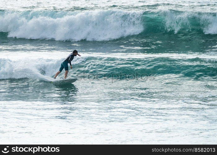 Local surfer riding waves with a short board in Furadouro beach, Portugal. Men catching waves in ocean. Surfing action water board sport.