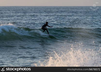 Local surfer riding waves with a short board in Furadouro beach, Portugal. Men catching waves in ocean. Surfing action water board sport.