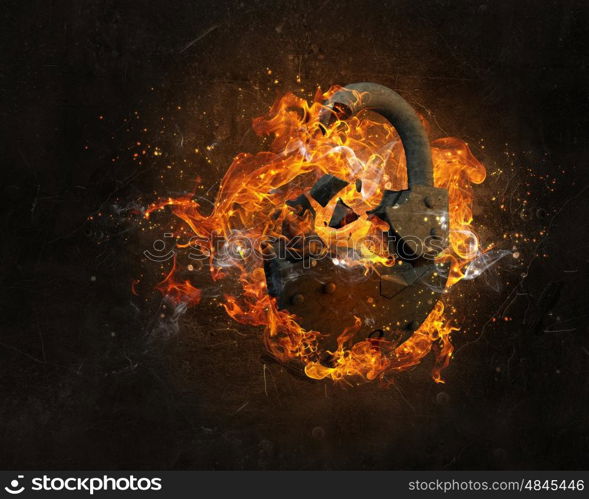 Lock burning in fire. Broken lock in fire flames on dark background