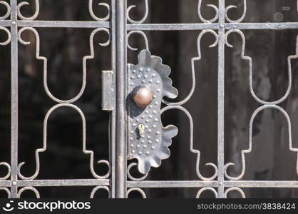 Lock on metal grid on closed black patio door closeup