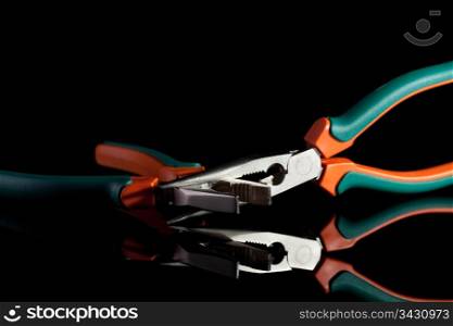 locked flat nose and needle nose pliers on black background