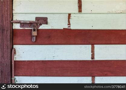Locked old wooden with red stripe door in Thailand