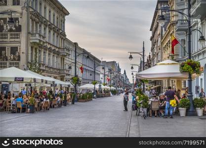 LODZ. POLAND - JULY 28, 2016 : Cafes and restaurants on Piotrkowska street in the evening. Poland