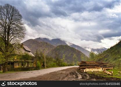 Logging in mountains. Spring stormy clouds. Rain in foggy green mountains