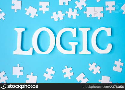 LOGIC text with white puzzle jigsaw pieces on blue background. Concepts of logical thinking, Conundrum, solutions, rational, strategy, world logic day and Education