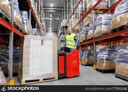 logistic business, shipment and loading concept - loader operating forklift with cargo at warehouse. loader operating forklift at warehouse