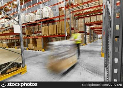 logistic business, shipment and loading concept - motion blurred picture of worker carrying loader with goods at warehouse. worker carrying loader with goods at warehouse