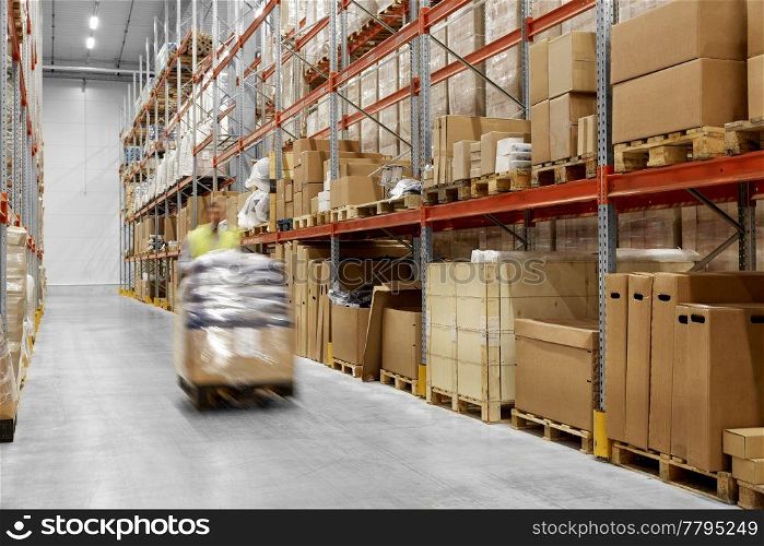 logistic business, shipment and loading concept - worker carrying loader with goods at warehouse. worker carrying loader with goods at warehouse