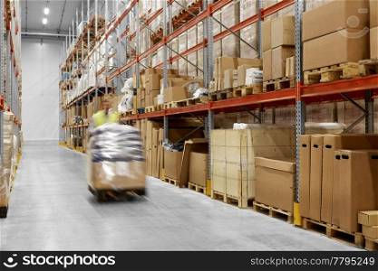logistic business, shipment and loading concept - worker carrying loader with goods at warehouse. worker carrying loader with goods at warehouse