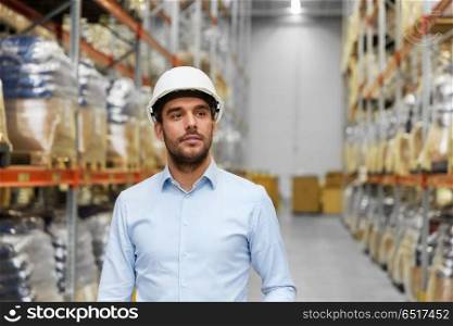 logistic business, shipment and people concept - businessman in helmet at warehouse. businessman in helmet at warehouse. businessman in helmet at warehouse