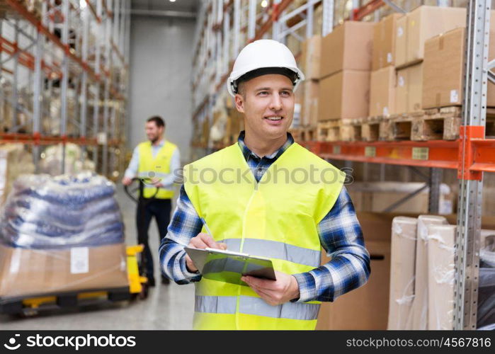 logistic business, shipment and people concept - smiling male worker or supervisor with clipboard in reflective safety vest at warehouse. warehouse worker with clipboard in safety vest. warehouse worker with clipboard in safety vest