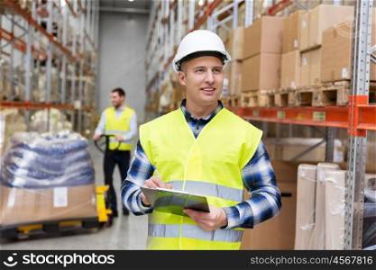 logistic business, shipment and people concept - smiling male worker or supervisor with clipboard in reflective safety vest at warehouse. warehouse worker with clipboard in safety vest. warehouse worker with clipboard in safety vest