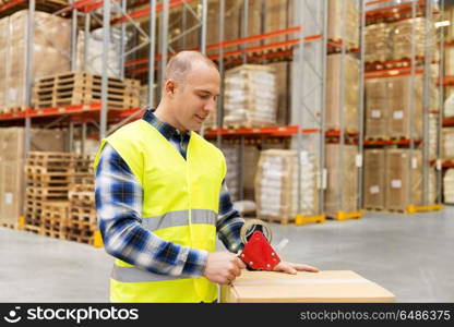 logistic business, shipment and people concept - worker in safety vest packing parcel box with scotch tape at warehouse or mail storage. warehouse worker packing parcel with scotch tape. warehouse worker packing parcel with scotch tape