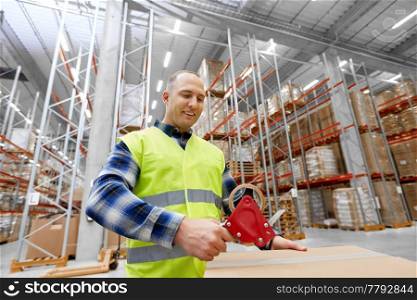 logistic business, shipment and people concept - worker in safety vest packing parcel box with scotch tape at warehouse or mail storage. warehouse worker packing parcel with scotch tape