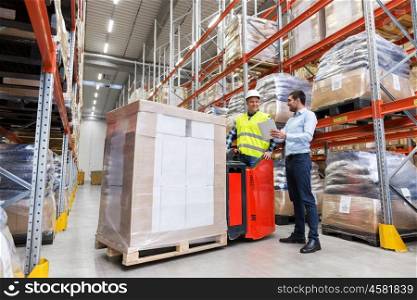 logistic business, technology and people concept - loader on forklift and businessman with tablet pc computer at warehouse. men with tablet pc and forklift at warehouse. men with tablet pc and forklift at warehouse